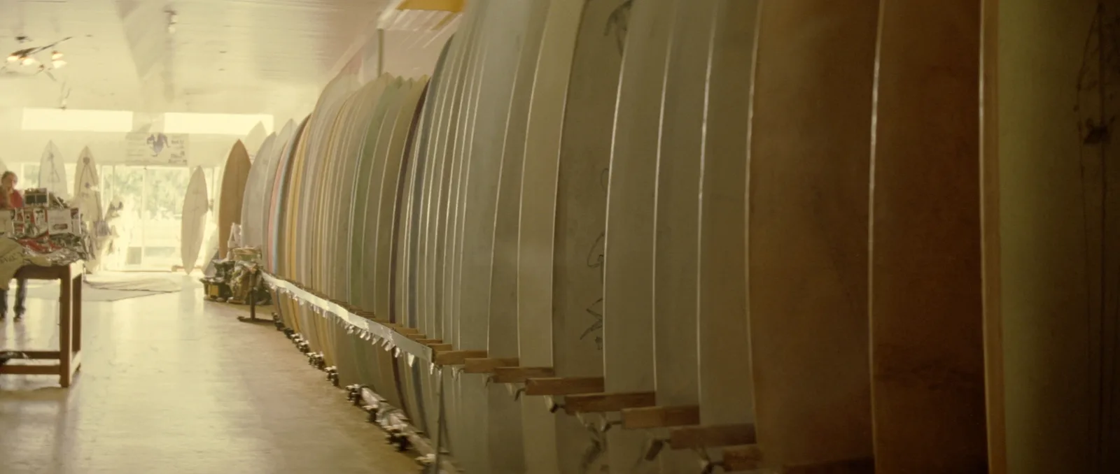 How to choose a surfboard — a surf shop rack holding boards of many different shapes and sizes