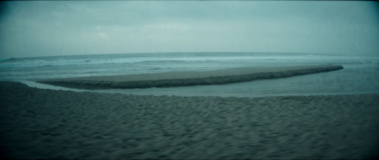 What size surfboard do I need — a surfer holding a board at the shoreline weighing up the choice